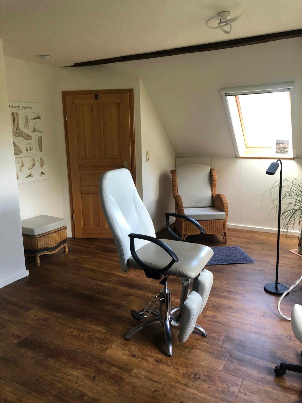 Behandlungsstuhl mit Sitzecke im Hintergrund